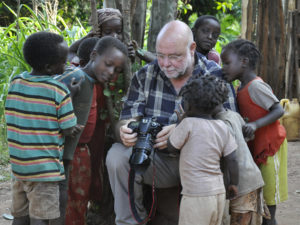 Der Fotograf Thomas Ammerpohl in Äthiopien, von Kindern umringt, denen er seine und ihre Bilder zeigt. Foto: Raue
